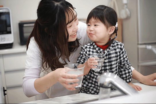 水道の水をコップに受ける親子