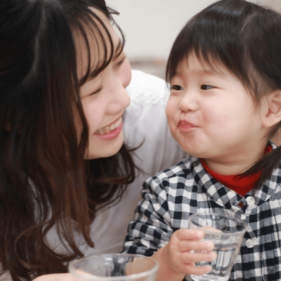 水道の水をコップに受ける親子